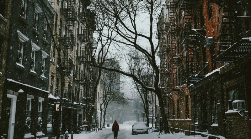 New York in February showing the Manhattan skyline and Empire State Building in winter with snow on the ground and clear skies representing what to expect visiting NYC in February