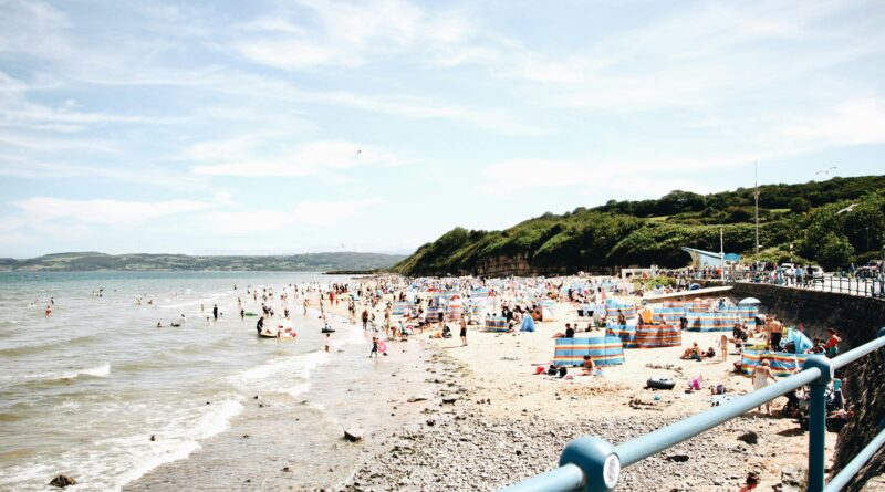 things to do in Anglesey showing Ynys Llanddwyn island at Newborough Beach with the Welsh coast and lighthouse visible representing the top attractions on the Isle of Anglesey in North Wales