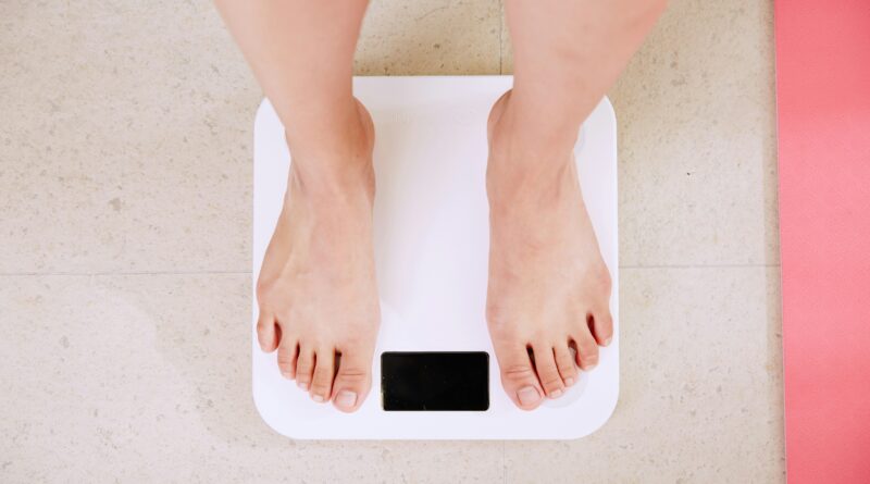 why am i not losing weight in a calorie deficit showing a person frustrated at weighing scales representing calorie deficit but not losing weight reasons why and how to break a weight loss plateau