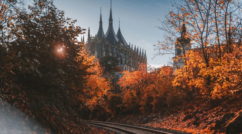 Kutna Hora Czech Republic showing St Barbara's Cathedral Gothic spires rising above the medieval town with the Jesuit College terrace and statues in the foreground
