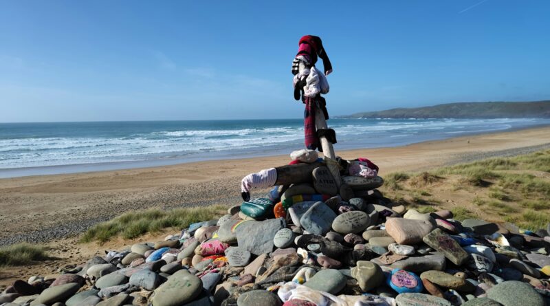 Dobby's Grave shrine at Freshwater West beach in Pembrokeshire Wales showing the fan-built memorial with painted stones and tributes in the sand dunes above the beach